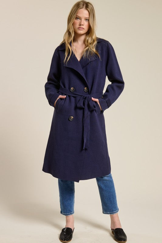 Model wearing a navy blue Trestles Clothing Company Beckham midi sweater coat with a tie belt over jeans