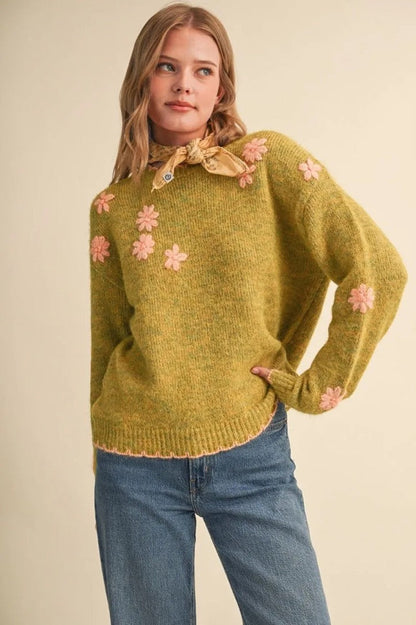 Trestles Clothing Company olive green knit sweater with pink floral embroidery, scalloped edges, and drop shoulders.