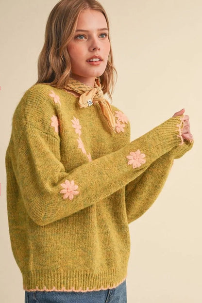 Trestles Clothing Company olive green knit sweater with pink floral embroidery, scalloped edges, and drop shoulders.