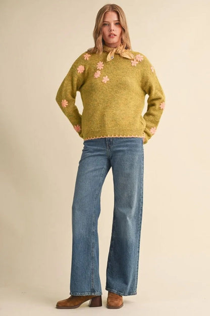 Trestles Clothing Company olive green knit sweater with pink floral embroidery, scalloped edges, and drop shoulders.