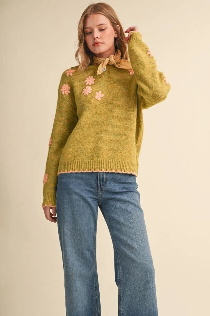 Trestles Clothing Company olive green knit sweater with pink floral embroidery, scalloped edges, and drop shoulders.
