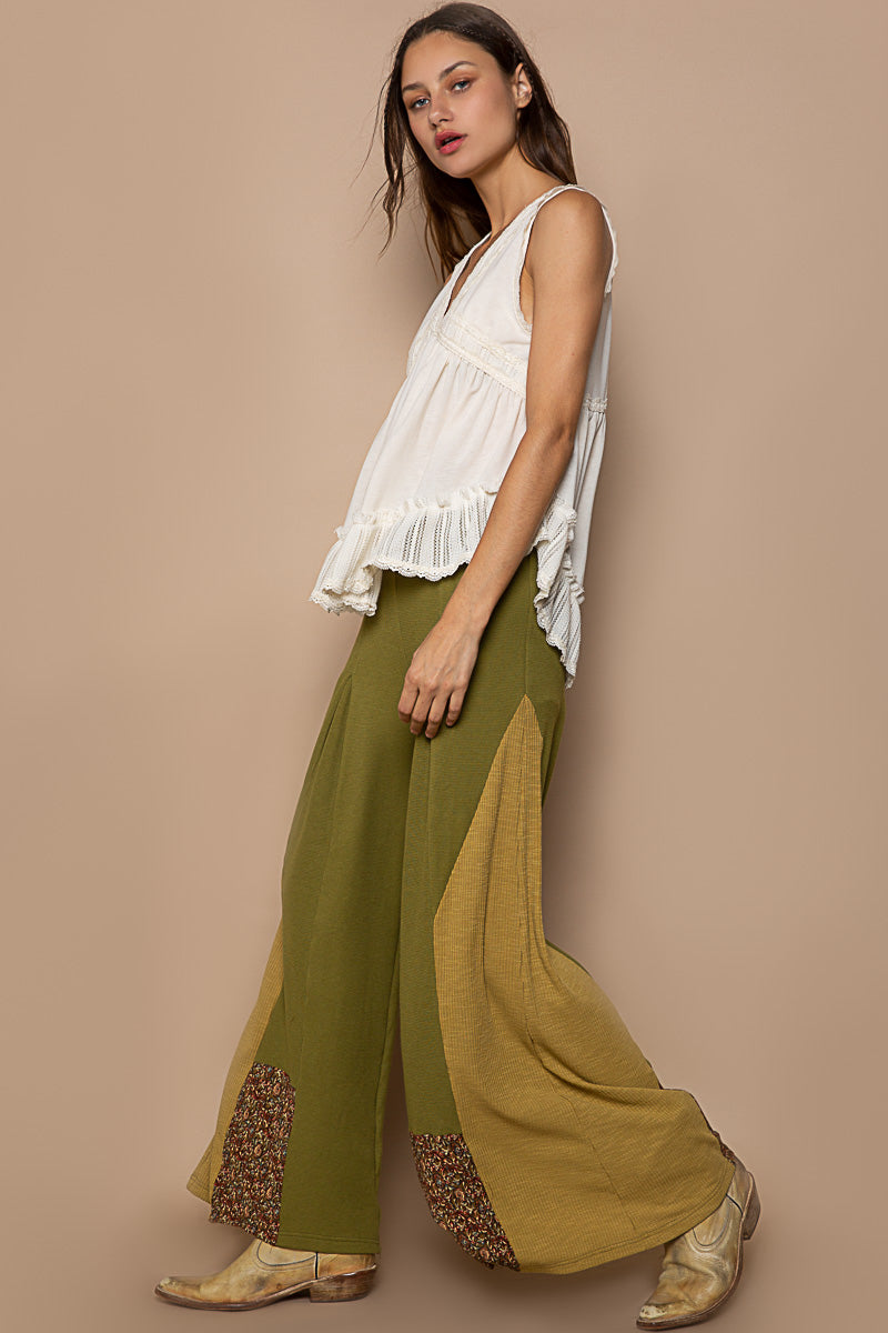 Trestles Clothing Company olive green knit flare pants with floral contrast panels and retro boho style
