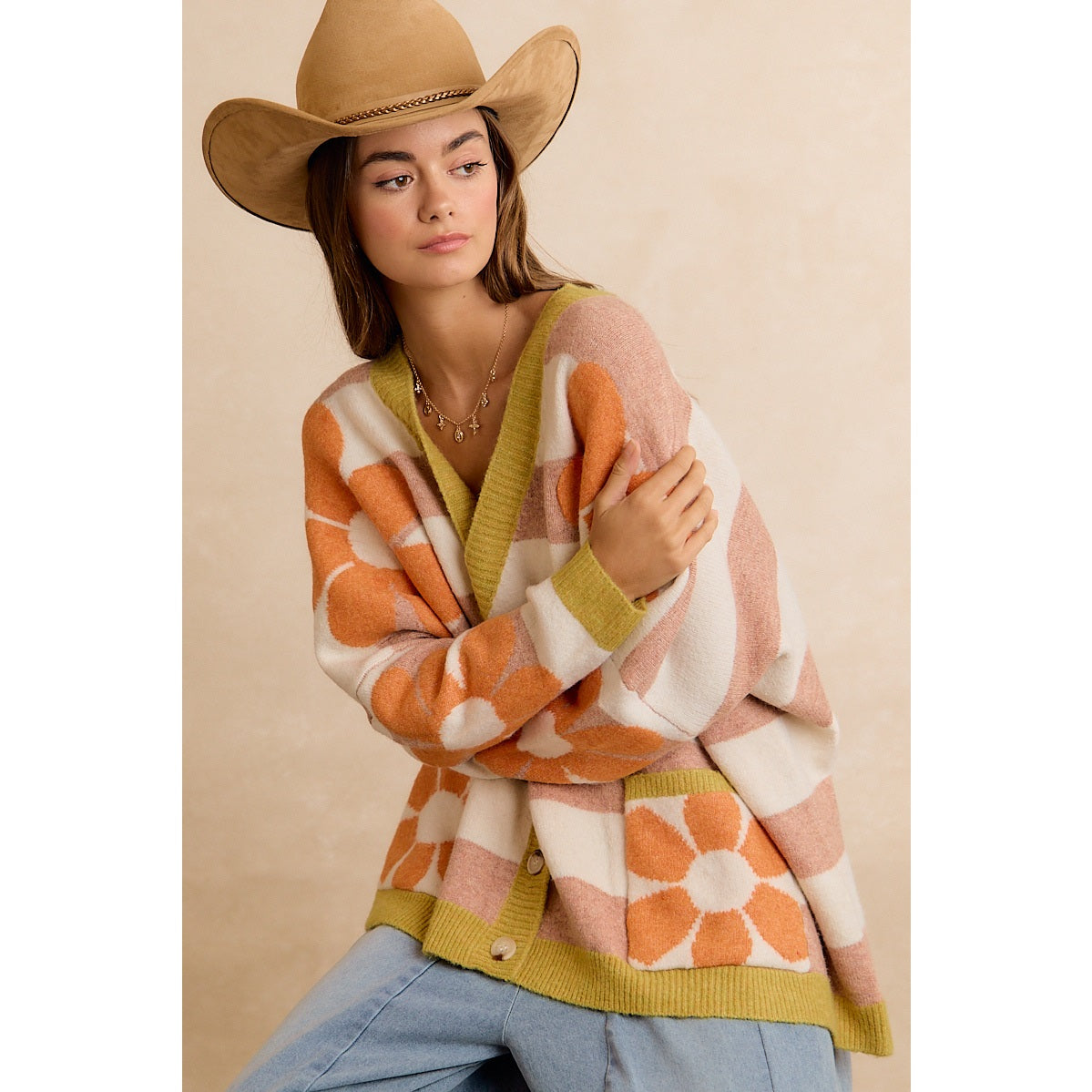 Trestles Clothing Company oversized floral knit cardigan with 70s retro stripes, worn by a model in a cowboy hat.