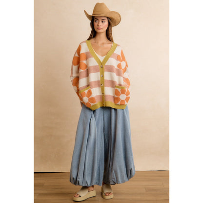 Trestles Clothing Company oversized knit cardigan with retro orange flowers and stripes, worn with a cowboy hat.