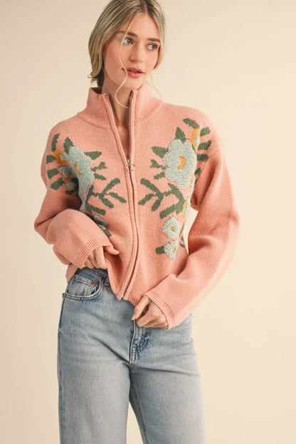 Trestles Clothing Company floral zip up knit sweater in pink with puff sleeves and stand collar on a model