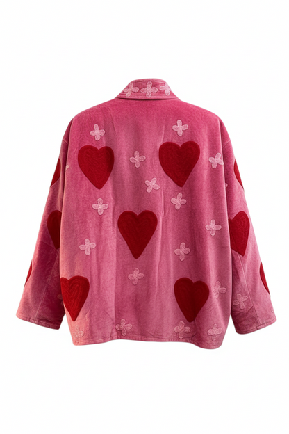 Back view of Trestles Clothing Company hot pink cotton velvet jacket featuring red heart and floral embroidery.