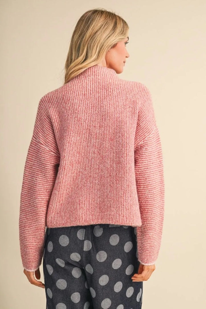 Trestles Clothing Company cozy pink knit sweater with a high neck, shown from the back on a blonde model