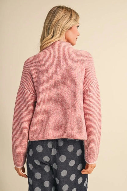 Trestles Clothing Company cozy pink knit sweater with a high neck, shown from the back on a blonde model