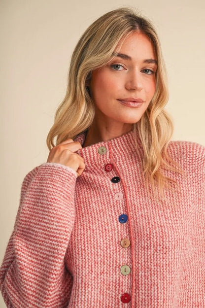 Trestles Clothing Company cozy pink knit sweater featuring a row of unique mismatched buttons on a high neckline