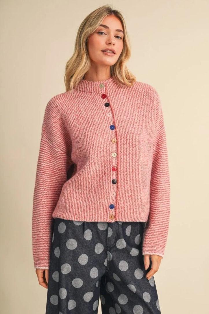 Trestles Clothing Company pink knit sweater featuring a high neck and unique mismatched colorful buttons.
