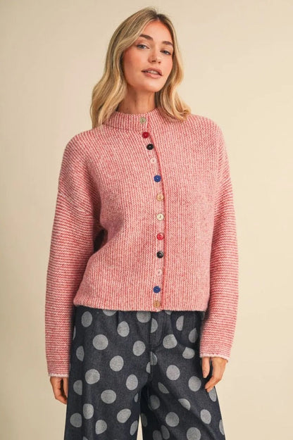 Trestles Clothing Company pink knit sweater featuring a high neck and unique mismatched colorful buttons.