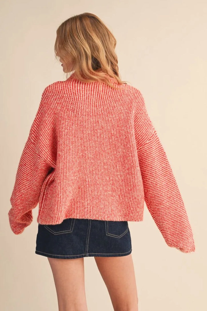 Back view of a woman wearing a cozy red and white textured knit sweater from Trestles Clothing Company