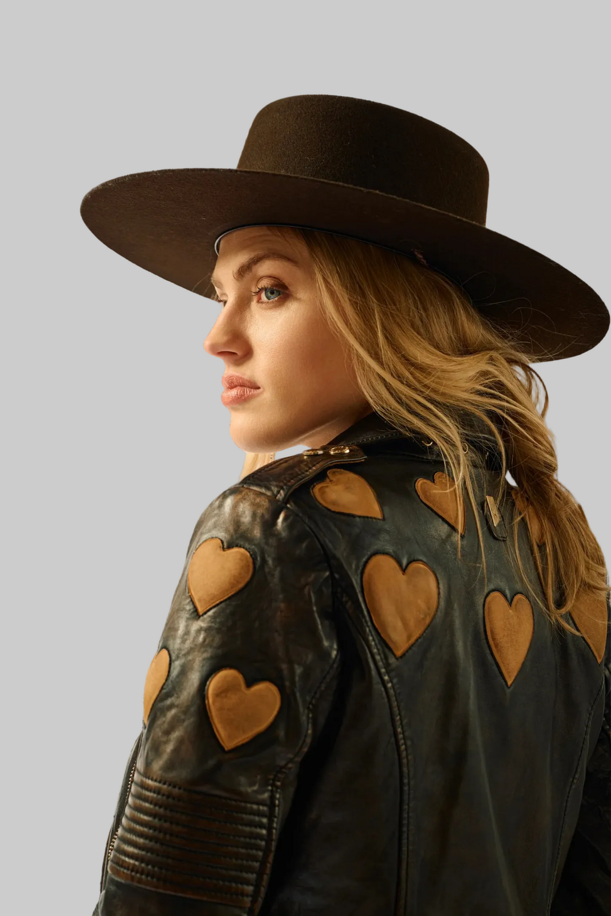 Trestles Clothing Company Reo 2 black lambskin leather moto jacket with tan heart patches worn with a wide-brim hat