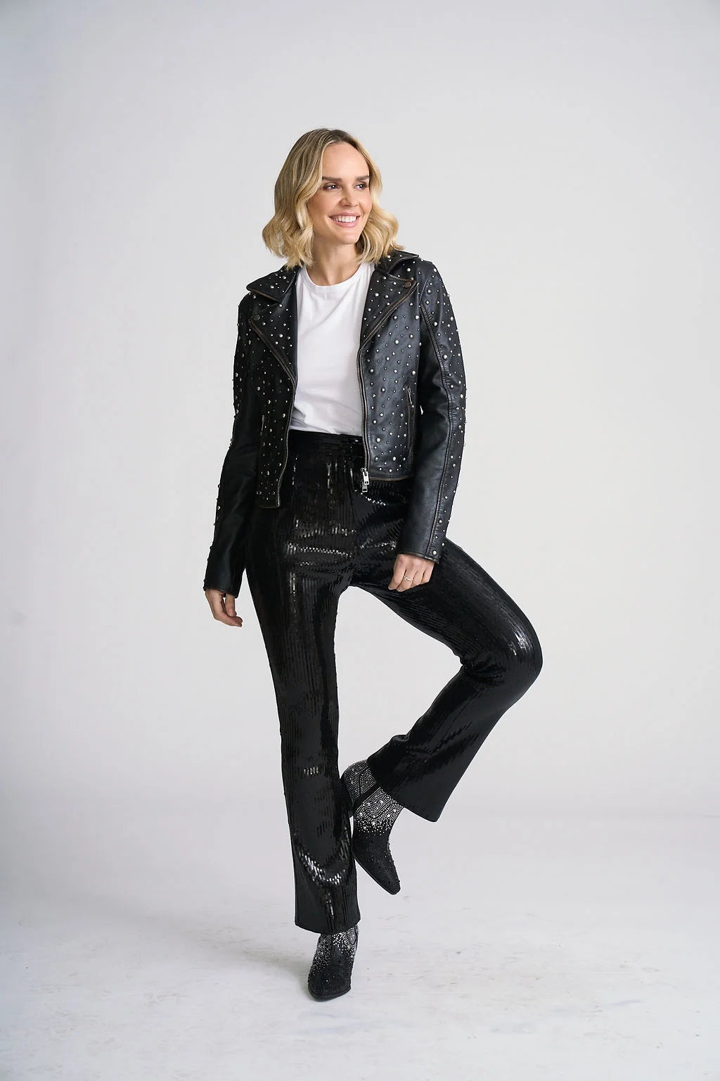 Model wearing Trestles Clothing Company Roxanne black lambskin leather jacket with silver studs over a white tee