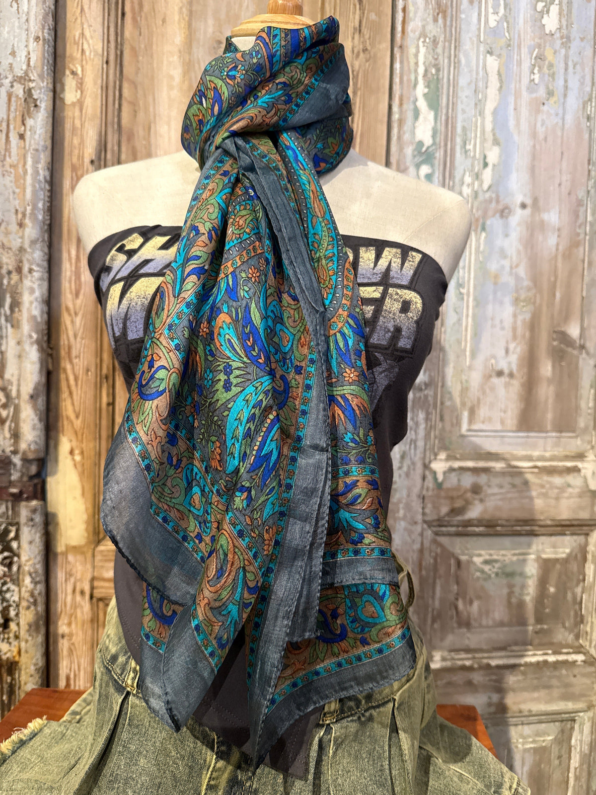 Trestles Clothing Company silk boho scarf with vibrant blue and green paisley print draped on a mannequin