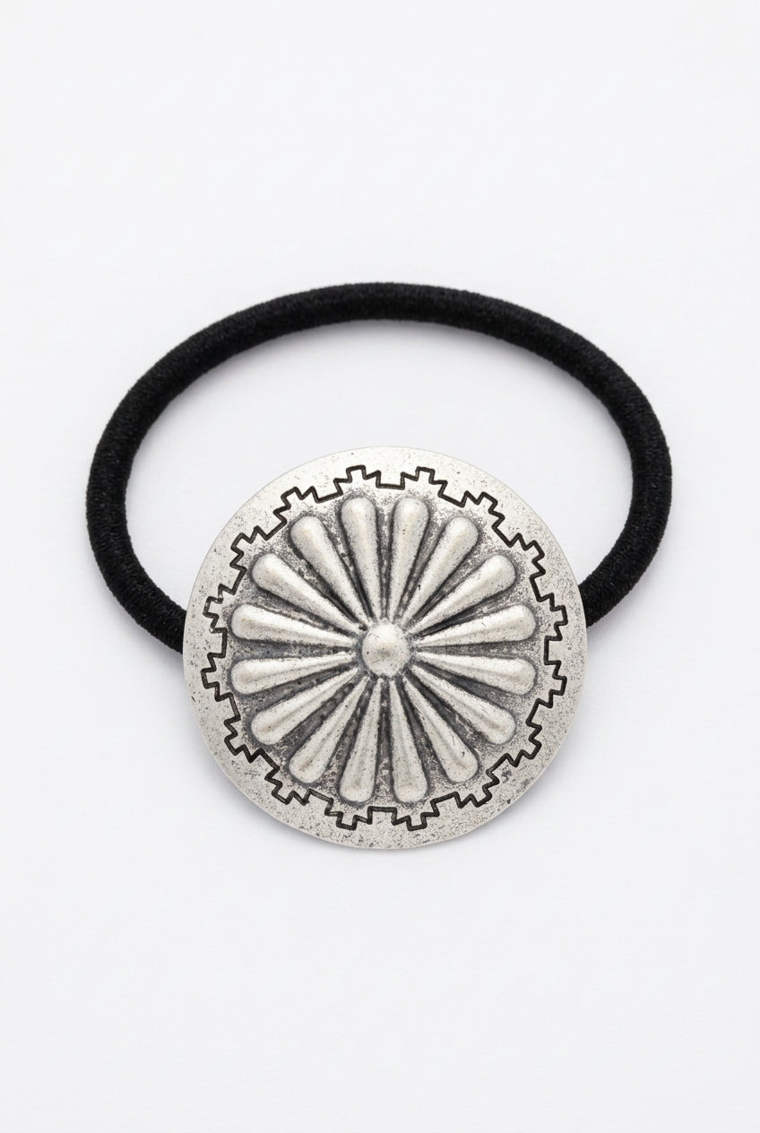 Trestles Clothing Company boho ponytail holder with a silver metal concho featuring a vintage western feather design.