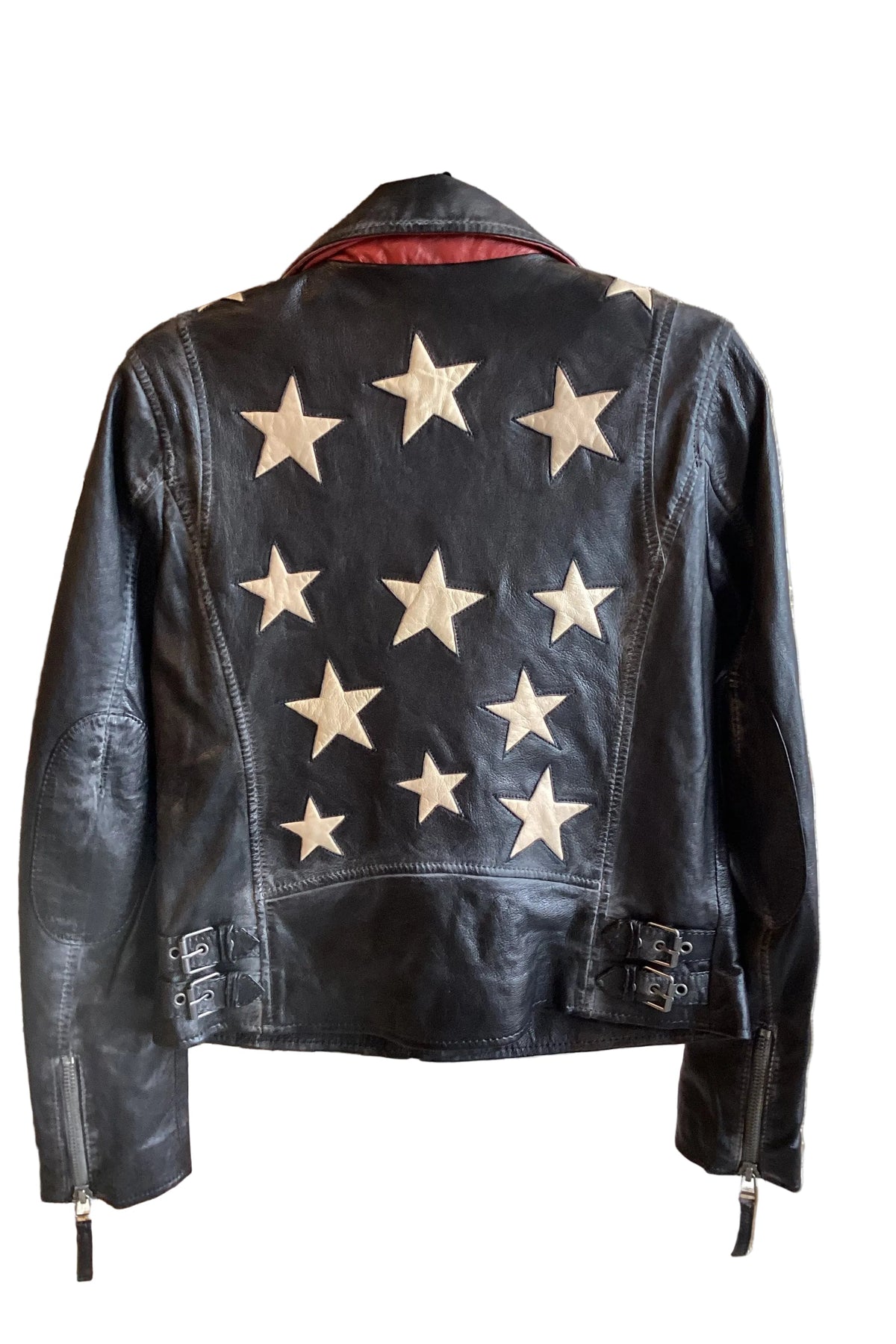 Trestles Clothing Company black lamb leather jacket with white star patches on the back and side buckle details.