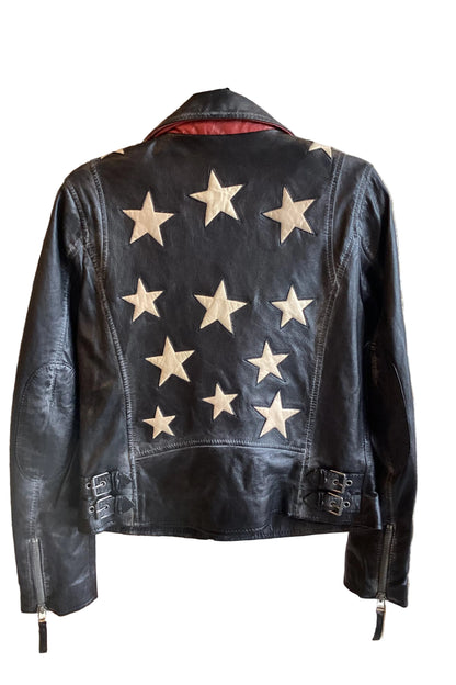 Trestles Clothing Company black lamb leather jacket with white star patches on the back and side buckle details.