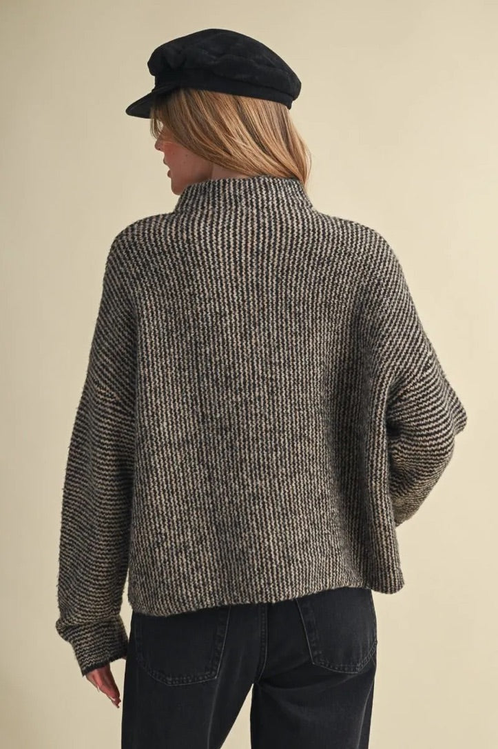 Back view of Trestles Clothing Company Buttons Sweater in a textured black and grey knit with a high collar