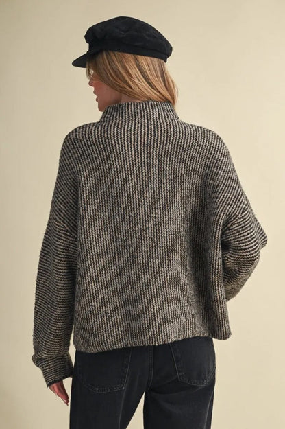 Back view of Trestles Clothing Company Buttons Sweater in a textured black and grey knit with a high collar