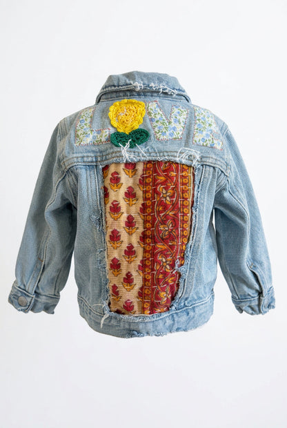 Trestles Clothing Company upcycled denim baby jacket with Indian Kantha patchwork, floral LOVE appliqué, and flower.