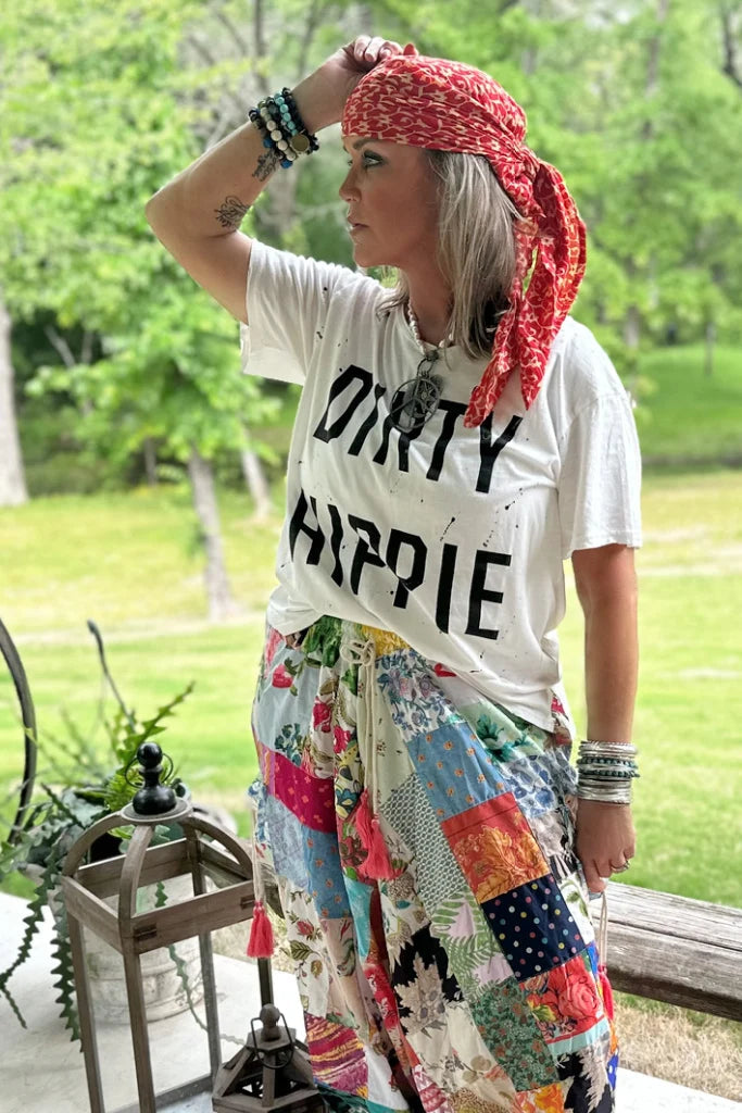 Trestles Clothing Company white Dirty Hippie graphic tee with short sleeves and scoop neck worn by a woman outdoors