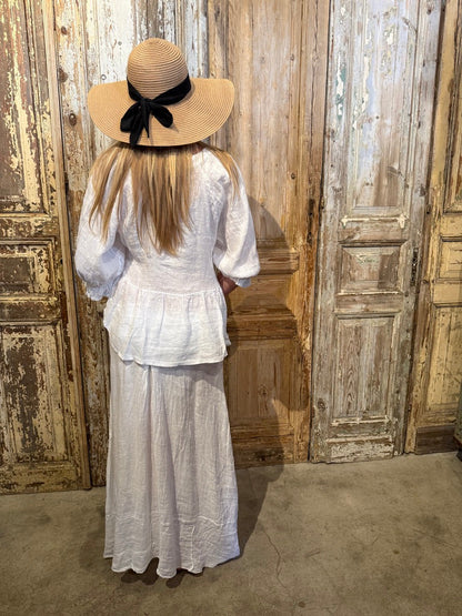 Trestles Clothing Company white linen maxi skirt with pieced design and soft waistband worn by a woman in a sun hat.