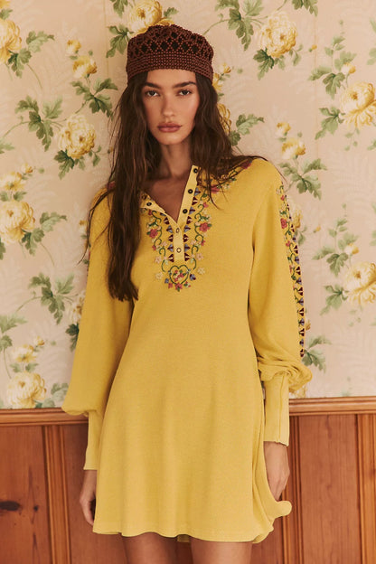 Trestles Clothing Company yellow ribbed knit mini dress with floral embroidery, balloon sleeves, and henley neckline.