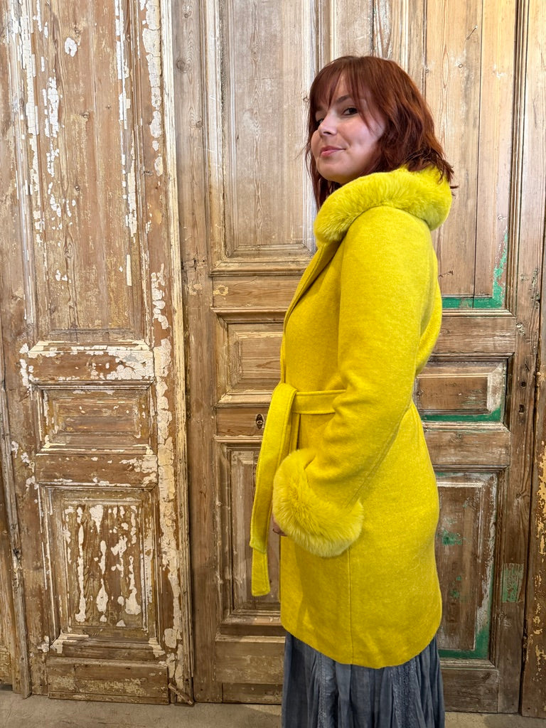 Trestles Clothing Company yellow coat with removable faux fur collar and cuffs, belted waist, side profile view.
