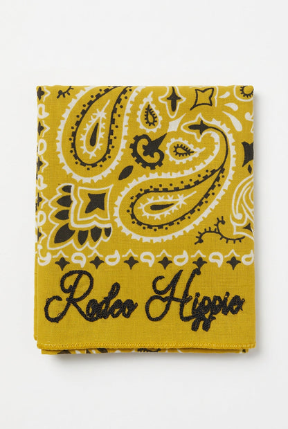 Trestles Clothing Company yellow paisley bandana with black chainstitched Rodeo Hippie text and stonewashed finish.